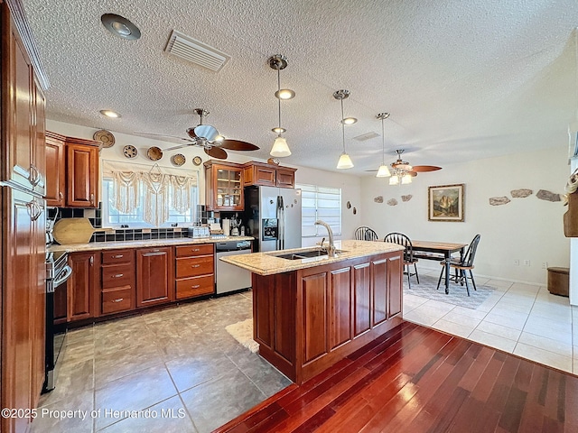 kitchen featuring appliances with stainless steel finishes, a healthy amount of sunlight, pendant lighting, and sink