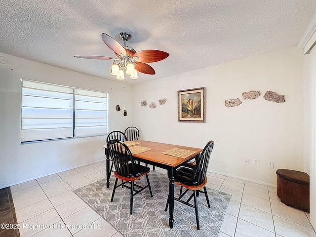 dining space with ceiling fan, light tile patterned floors, and a textured ceiling