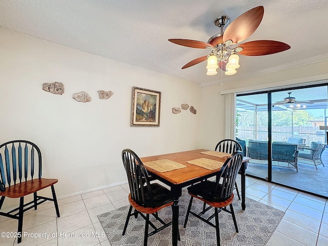 dining area with ceiling fan, light tile patterned floors, and a textured ceiling