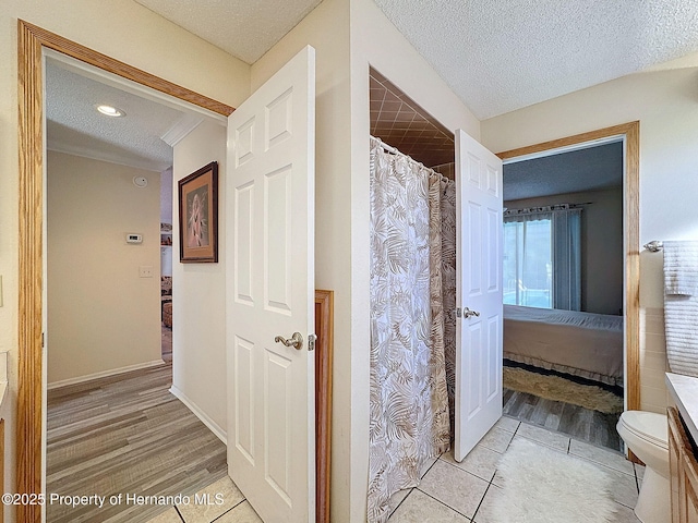 bathroom with a textured ceiling, tile patterned floors, and vanity