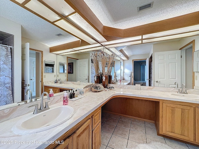 bathroom featuring a textured ceiling, tile patterned floors, and vanity