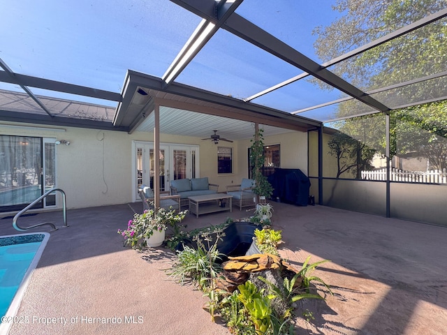 view of patio featuring glass enclosure, ceiling fan, a grill, and outdoor lounge area