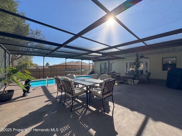 view of patio with a lanai, ceiling fan, and a fenced in pool