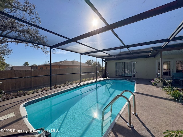 view of swimming pool featuring a patio area and glass enclosure