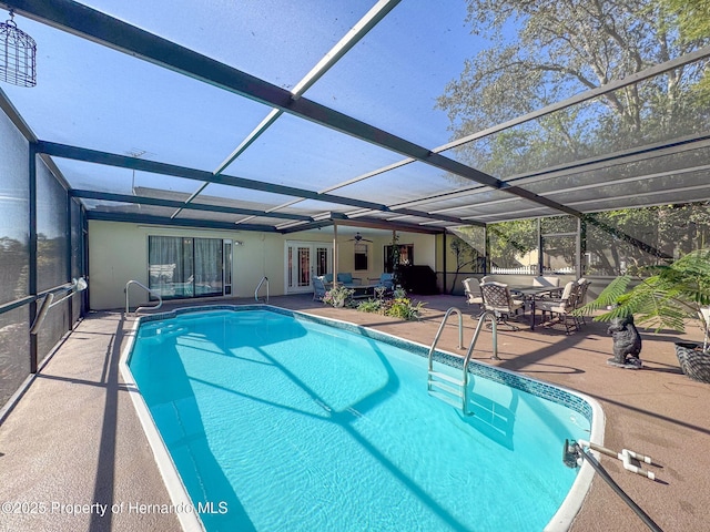 view of swimming pool featuring glass enclosure and a patio area