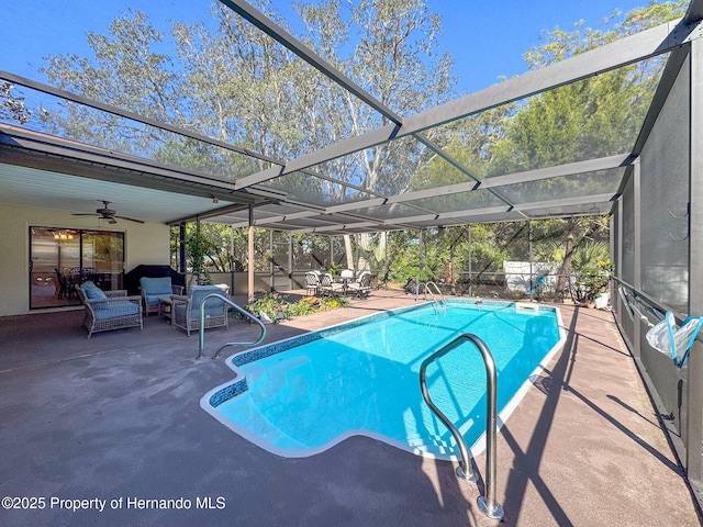 view of swimming pool with glass enclosure, ceiling fan, and a patio