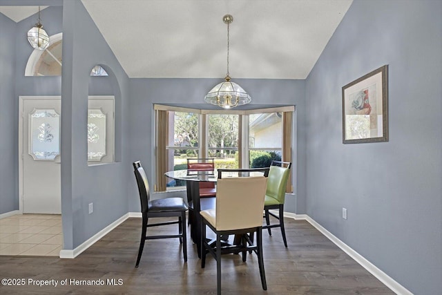 dining room featuring dark hardwood / wood-style floors and vaulted ceiling