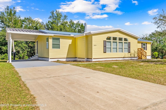 view of front of property with a front lawn and a carport