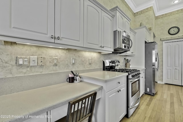 kitchen featuring light hardwood / wood-style floors, white cabinetry, appliances with stainless steel finishes, and crown molding