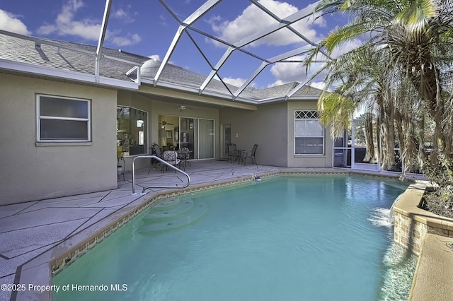 view of pool with ceiling fan, a patio area, and glass enclosure