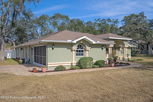 view of front facade featuring central AC, a patio, and a front yard