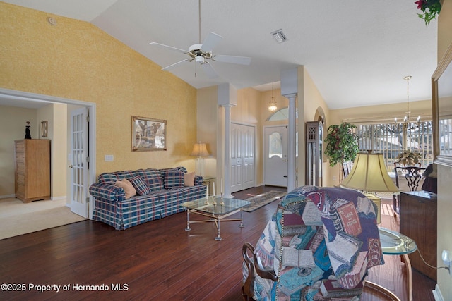 living room with ceiling fan with notable chandelier, dark hardwood / wood-style flooring, high vaulted ceiling, and ornate columns