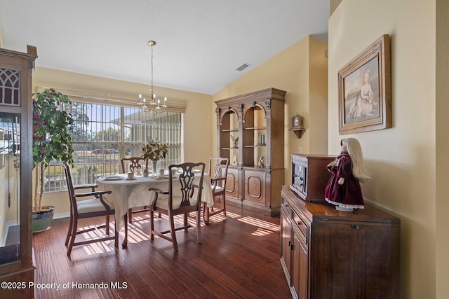 dining space featuring a notable chandelier, dark wood-type flooring, and vaulted ceiling