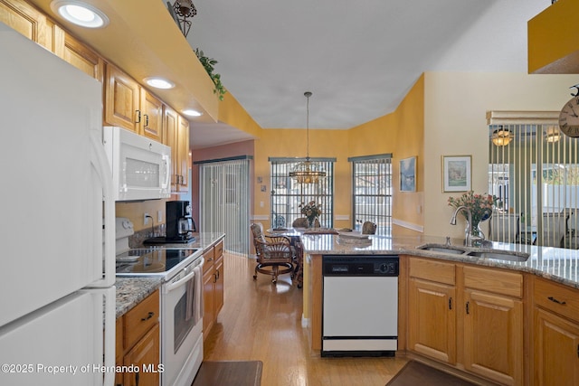 kitchen featuring sink, white appliances, light hardwood / wood-style flooring, light stone countertops, and decorative light fixtures