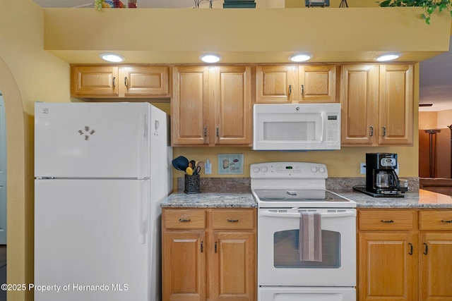 kitchen featuring light stone countertops and white appliances