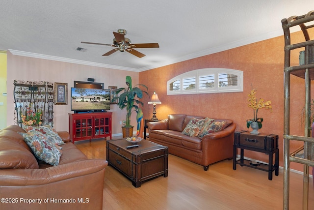 living room with ceiling fan, ornamental molding, and light hardwood / wood-style flooring