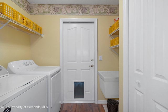 clothes washing area with dark hardwood / wood-style floors, sink, and independent washer and dryer