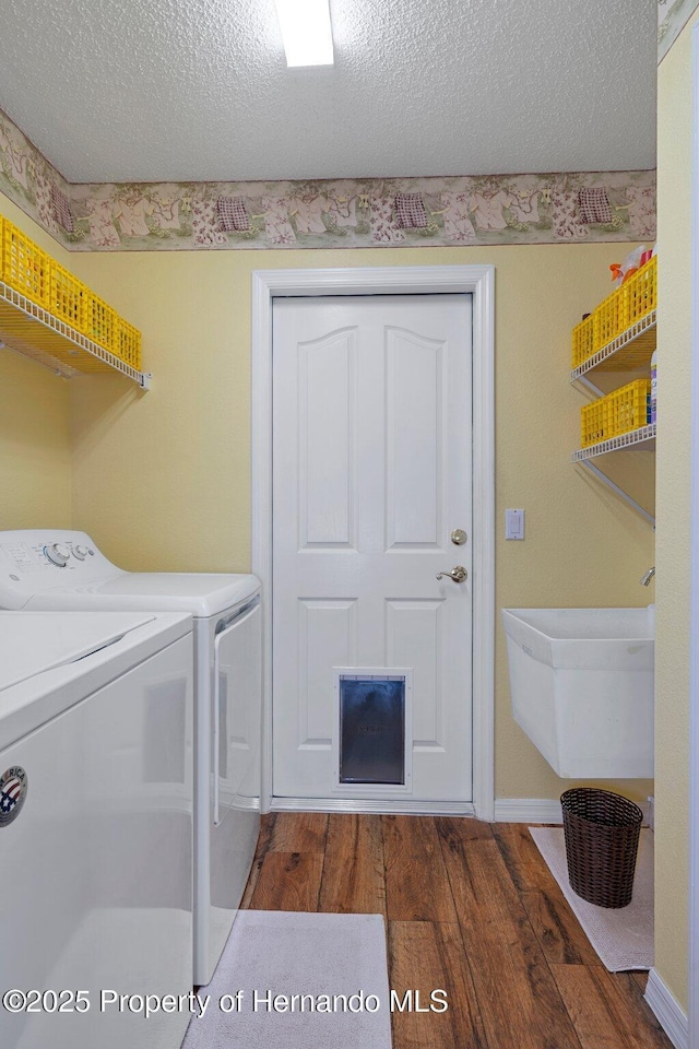 laundry area with washer and dryer, a textured ceiling, and dark hardwood / wood-style flooring