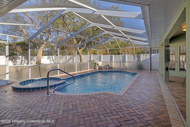 view of swimming pool featuring a patio, an in ground hot tub, french doors, and glass enclosure