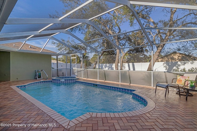 view of swimming pool with an in ground hot tub, a lanai, and a patio area