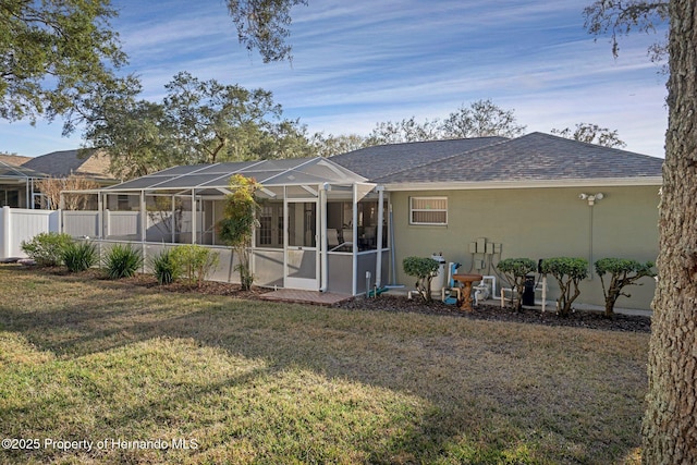 rear view of property featuring a yard and a lanai