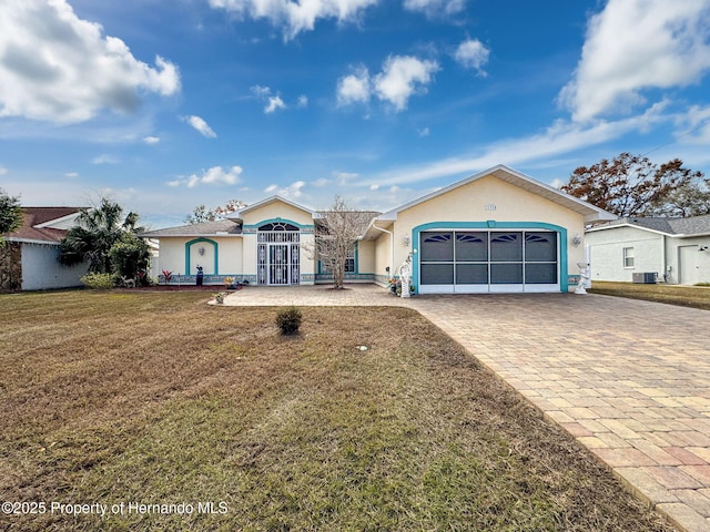 single story home with central AC unit, a front yard, and a garage