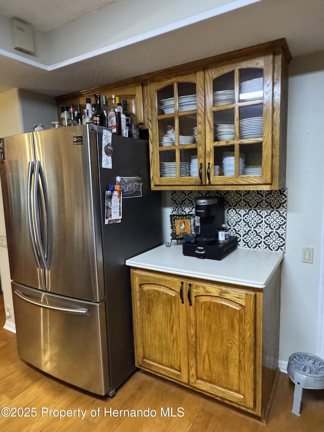 kitchen featuring backsplash, stainless steel fridge, and light hardwood / wood-style floors