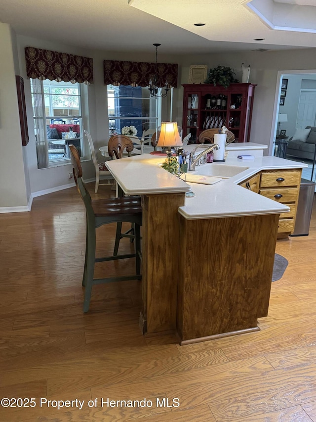 kitchen featuring hanging light fixtures, an island with sink, sink, and an inviting chandelier