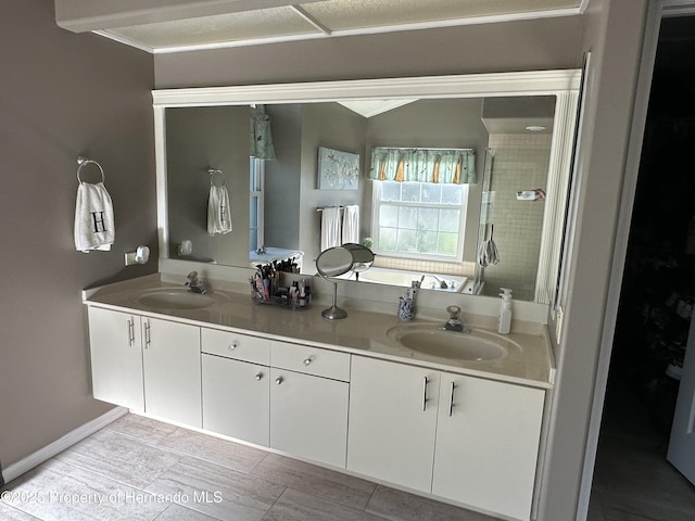 full bathroom featuring double vanity, a stall shower, vaulted ceiling, and a sink