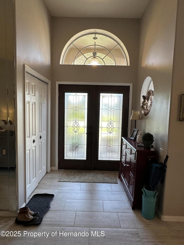 foyer entrance with french doors and a towering ceiling