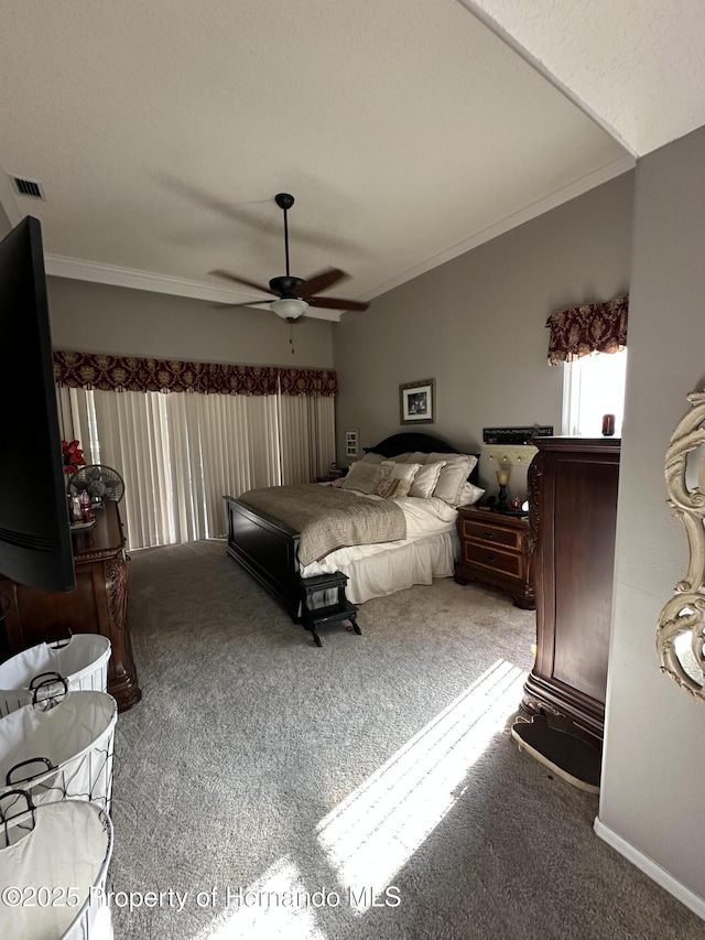 bedroom with carpet floors, visible vents, crown molding, and ceiling fan