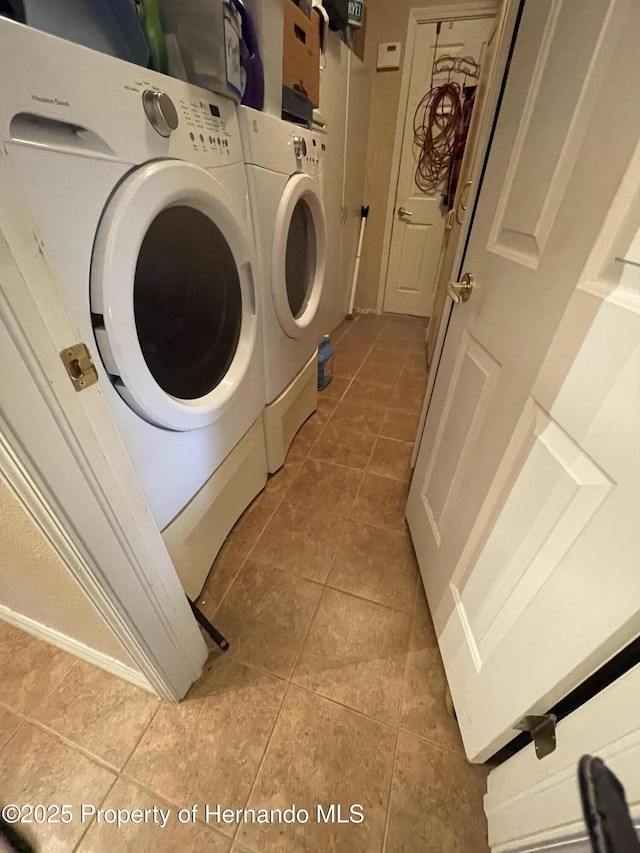 laundry area with washing machine and dryer and light tile patterned floors