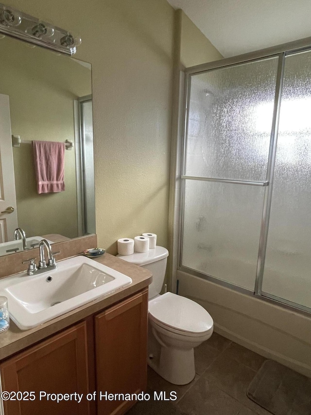 full bathroom featuring combined bath / shower with glass door, toilet, tile patterned floors, and vanity