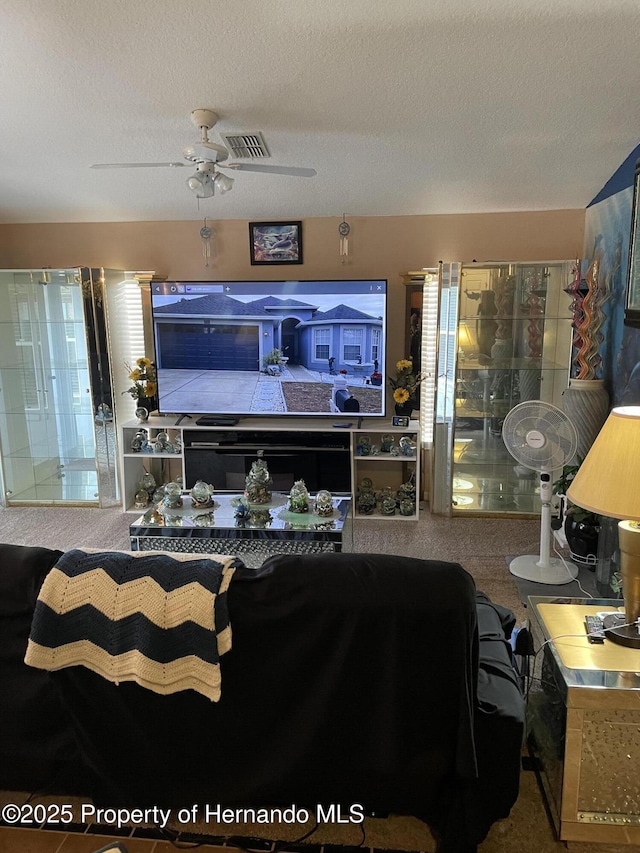 interior space with ceiling fan, a textured ceiling, and carpet floors