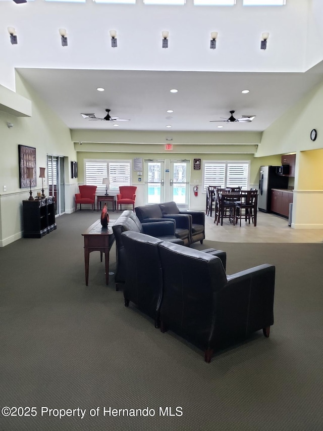 carpeted living room with ceiling fan