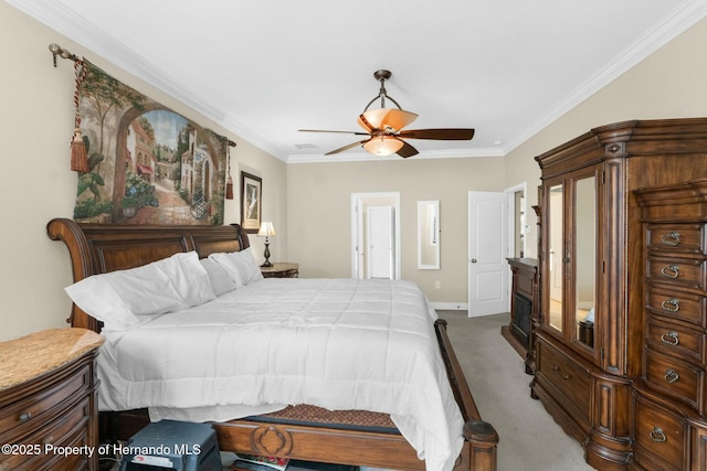 carpeted bedroom with ceiling fan, baseboards, and crown molding