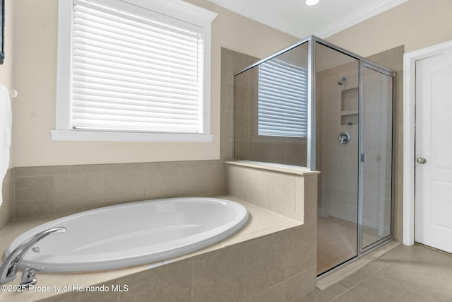 bathroom with a stall shower, a garden tub, crown molding, and tile patterned floors