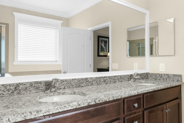 bathroom featuring ornamental molding, a shower with shower door, a sink, and double vanity