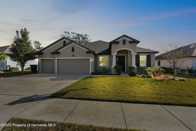 view of front of house with an attached garage, driveway, a front yard, and stucco siding