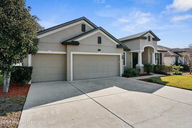 view of front of house featuring a garage, driveway, and stucco siding