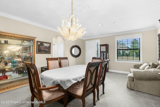 dining area with arched walkways, crown molding, light colored carpet, an inviting chandelier, and baseboards