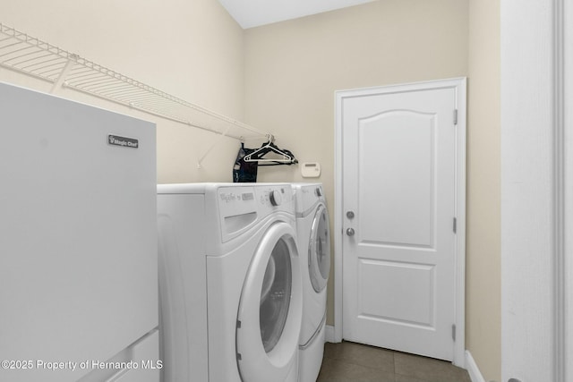 washroom featuring laundry area, washing machine and dryer, and tile patterned floors