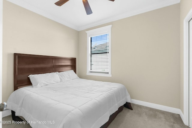 carpeted bedroom with a ceiling fan, crown molding, and baseboards