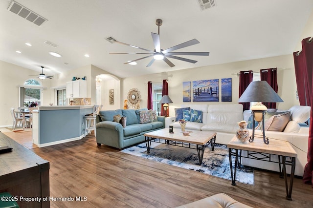 living room featuring ceiling fan, wood-type flooring, and lofted ceiling