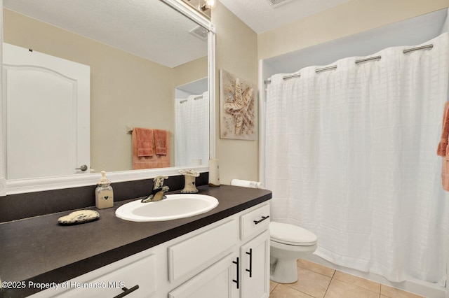 bathroom featuring toilet, a textured ceiling, tile patterned floors, and vanity