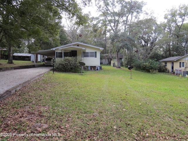 view of front of home with a front yard and a carport