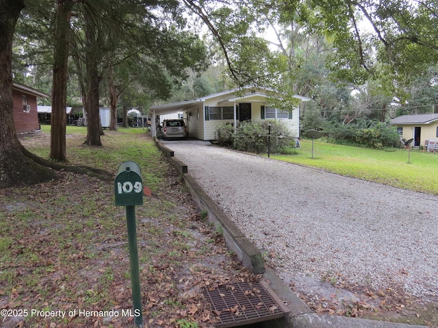 ranch-style house with a front yard and a carport