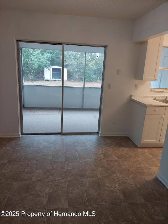 interior space featuring sink and white cabinetry