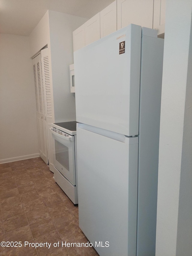 kitchen with white cabinetry and white appliances