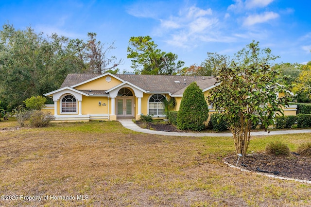 ranch-style home featuring a front yard and french doors